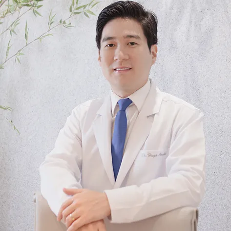 Dr. Hugo Araki, oftalmologista, de jaleco branco no consultório